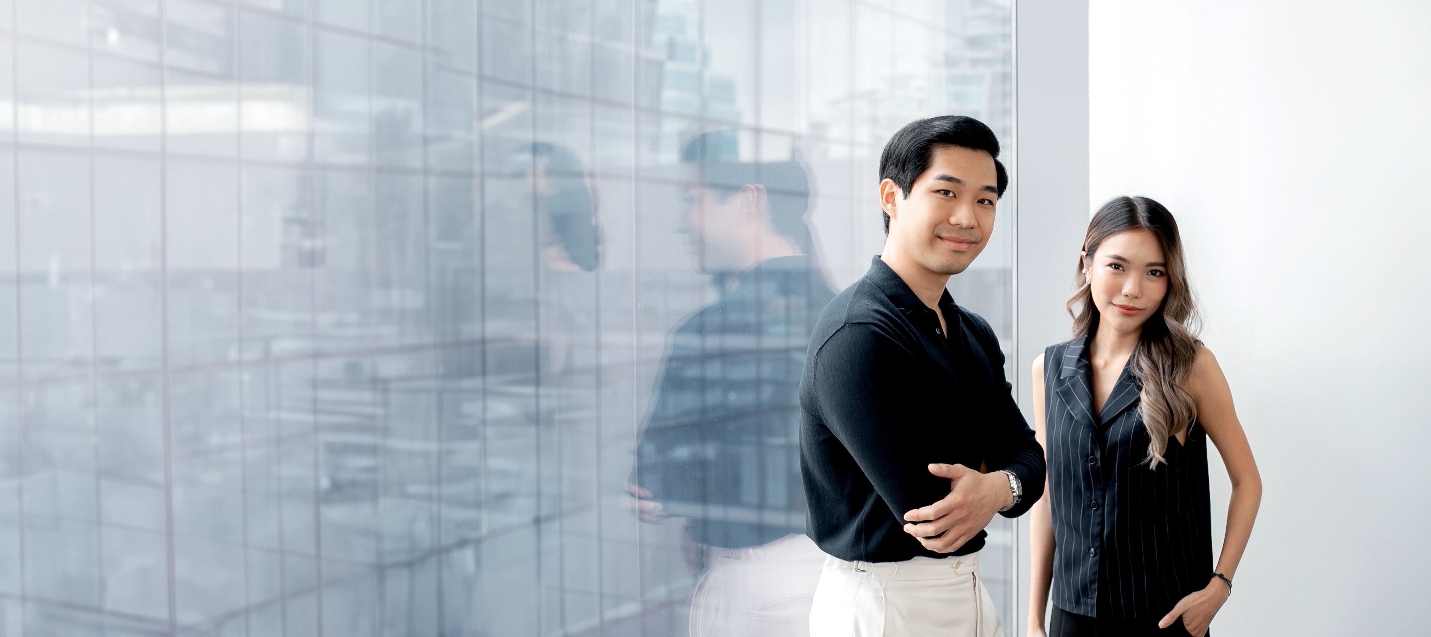 Two Primal team members beside the office glass wall