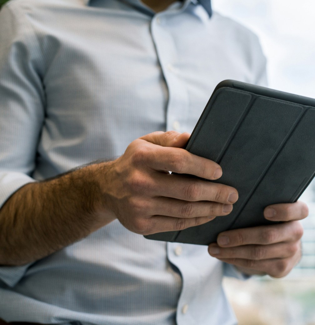 A person in a light blue shirt holding a tablet