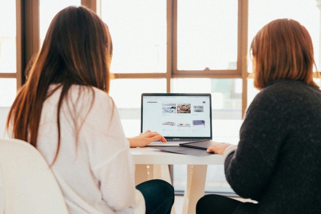 Two colleagues reviewing a report together on a desktop computer